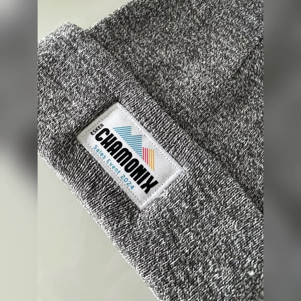 Gros plan sur le patch tissé Esker Chamonix d'un bonnet gris chiné