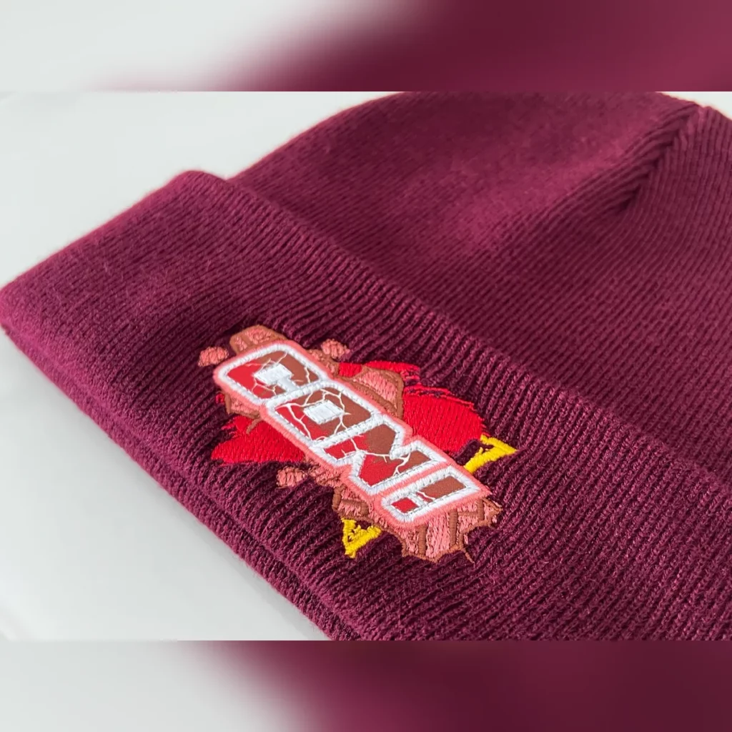 Gros plan sur une broderie multicolore sur un bonnet bordeaux