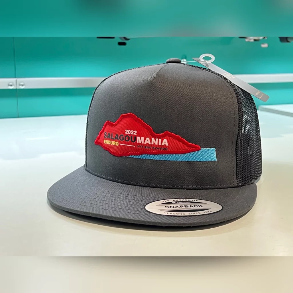 Casquette snapback grise à filet avec un écusson brodé rouge et bleu