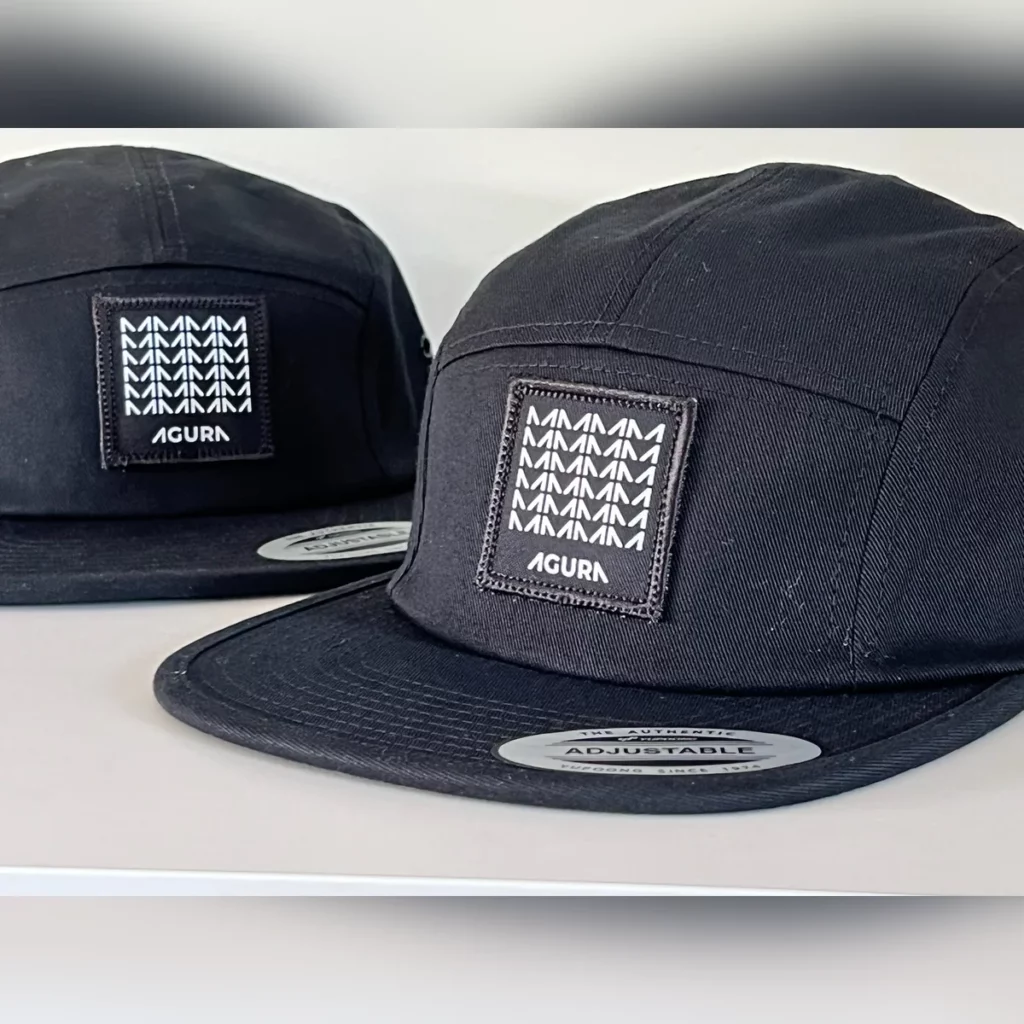Casquettes 5 panel noires avec un patch tissé Agura